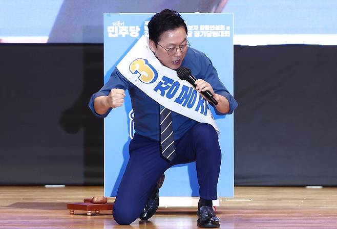 정봉주 더불어민주당 최고위원 후보가 21일 오전 강원 홍천종합체육관에서 열린 제1회 전국당원대회 강원지역 합동연설회에서 무릎을 꿇고 주먹을 쥔 채 정견발표를 하고 있다. 뉴스1