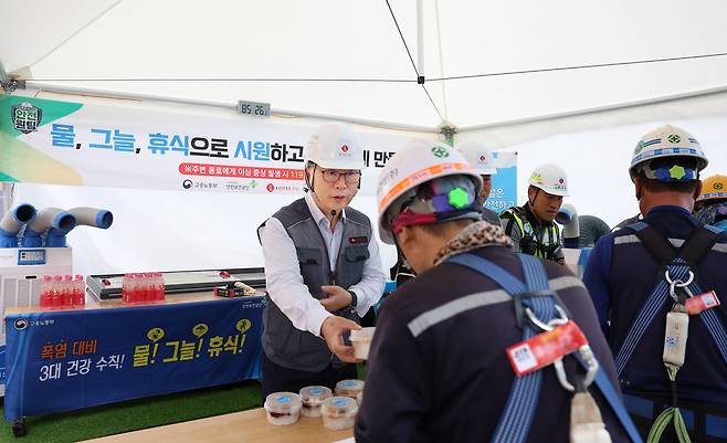 박현철 롯데건설 부회장이 혹서기를 맞아 ‘천안 롯데캐슬 더 청당 현장’에서 근로자들에게 팥빙수, 건강음료, 혹서기 용품 등을 나눠주고 있다. [롯데건설 제공]