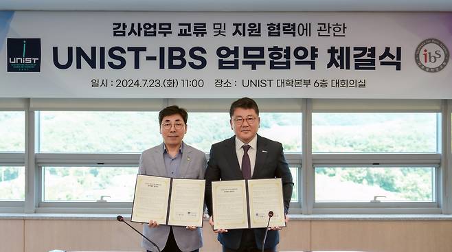 최도영 IBS 상임감사(왼쪽)와 이광우 UNIST 상임감사 협정서를 들고 기념사진을 촬영하고 있다.[UNIST 제공]