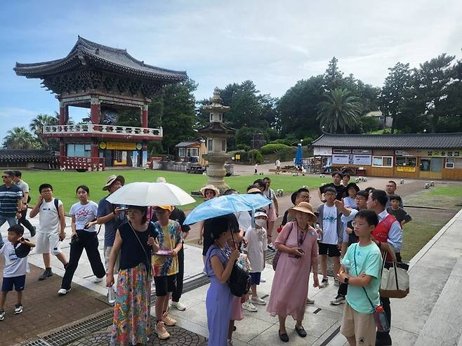 크루즈 관광객들이 지난 17일 서귀포시 중문동 약천사에서 여행가이드의 설명을 듣고 있다.