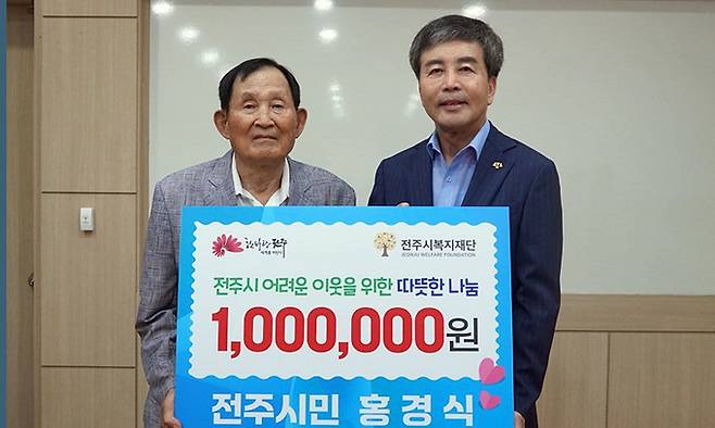 홍경식씨(왼쪽)가 23일 전주시복지재단을 찾아 폐지를 주워 판 돈 100만원을 윤방섭 이사장에게 전달하고 있다. 전주시 제공