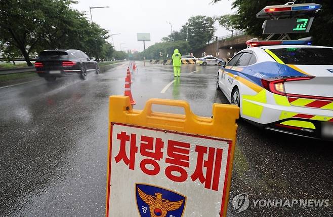 올림픽대로 여의상류IC 교통 통제 (서울=연합뉴스) 신현우 기자 = 수도권에 이틀째 집중호우가 쏟아진 지난 18일 오후 서울 올림픽대로 양방향 여의상류IC를 경찰이 통제하고 있다.