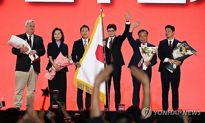 국민의힘 새 지도부 (고양=연합뉴스) 김주성 기자 = 국민의힘 한동훈 당대표 당선자가 23일 오후 고양 킨텍스에서 열린 국민의힘 제4차 전당대회에서 당기 인수 후 최고위원 당선자들과 기념촬영 하고 있다. 왼쪽부터 인요한·김민전·장동혁 최고위원. 한동훈 당대표. 김재원 최고위원, 진종오 청년최고위원. 2024.7.23 [공동취재] utzza@yna.co.kr