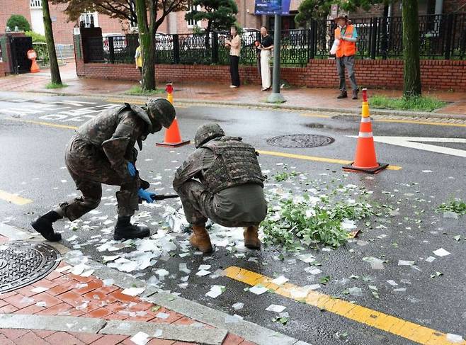 북한에서 부양한 대남 쓰레기 풍선 내용물이 24일 오전 서울 중구 국립정동극장 인근에 떨어져 군 관계자들이 내용물을 살펴보고 있다. [이미지출처=연합뉴스]