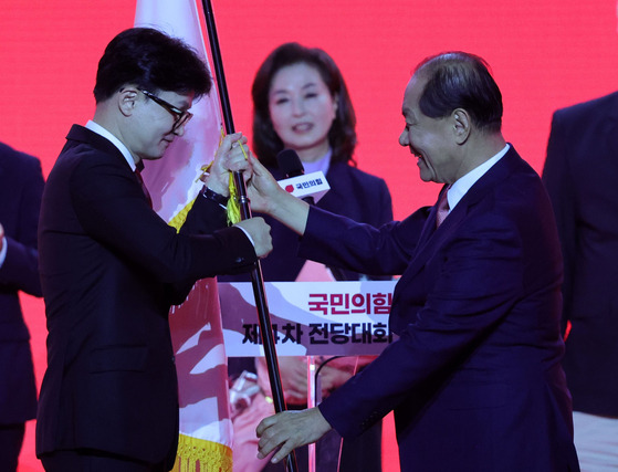 국민의힘 당 대표로 선출된 한동훈 후보가 23일 경기 고양 킨텍스에서 열린 제4차 국민의힘 전당대회에서 황우여 비상대책위원장으로부터 당기를 건네받고 있다.뉴스1