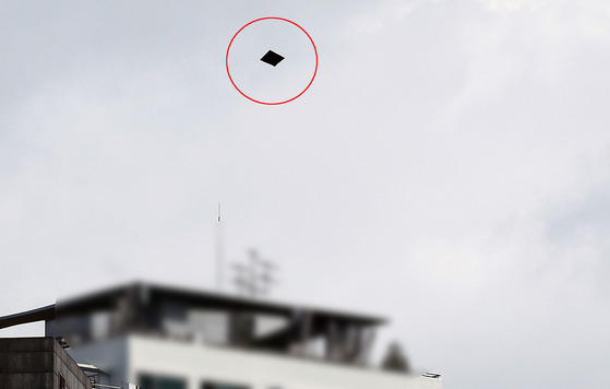 A balloon carrying trash from North Korea, circled in red, descends on the compound of the South Korean presidential office in Yongsan in central Seoul on Wednesday. [NEWS1]