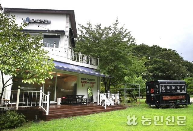 잔디마당과 푸드 트레일러가 있는 도시외양간 매장 전경.