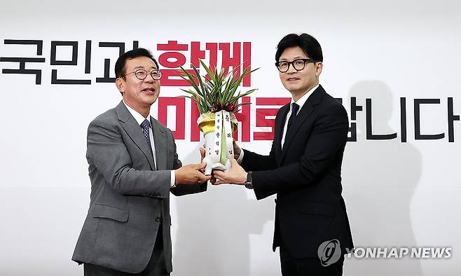 윤 대통령 축하 난 전달받는 한동훈 당 대표 (서울=연합뉴스) 김주형 기자 = 국민의힘 한동훈 신임 대표가 24일 오후 국회를 예방한 홍철호 대통령실 정무수석(왼쪽)으로부터 윤석열 대통령의 축하 난을 받고 있다. 2024.7.24 kjhpress@yna.co.kr