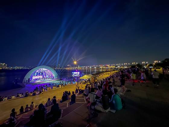 People watch a performance near the Han River in an undated photo provided by the Seoul city government on Thursday. [SEOUL METROPOLITAN GOVERNMENT]