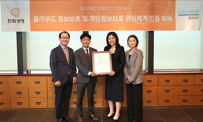 지난 24일 오전 63빌딩에서 열린 ISO·IEC 27017, 27018 인증 수여식에서한화생명이 인증서를 수여받았다. 한화생명 이창희 COE부문장(사진 좌측 두번째)과 DNV 비즈니스어슈어런스코리아 이소영 대표(사진 우측 두번째), 한화생명 조병선 CISO(좌측 첫번째), DNV 비즈니스어슈런스코리아 류현정 운영실장(우측 첫번째)이 기념촬영을 하고 있다.