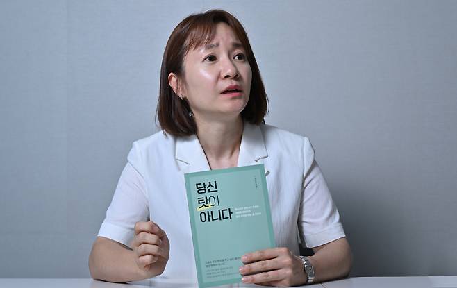 채다은 변호사가 저서 ‘당신 탓이 아니다’를 들어 보이고 있다. 임세준 기자