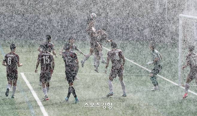 충북 제천시 제천축구센터에서 24일 열린 제57회 대통령금배 전국고등학교축구대회 인천강화스포츠클럽U18과 강원 상지대관령고의 16강 진출 결정전 경기에서 선수들이 폭우 속에서 공중볼 다툼을 벌이고 있다. 2024.07.24. /서성일 선임기자