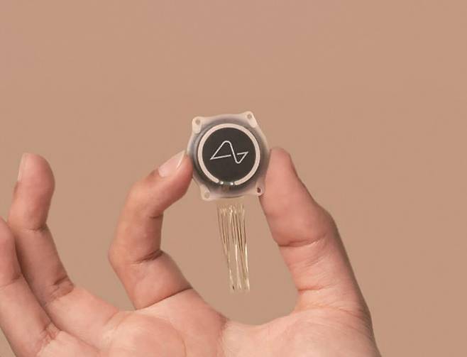 뉴럴링크의 N1 임플란트 칩. 지름 23mm, 높이 8mm 크기의 원판에 64가닥의 실이 붙어 있는 형태다. 실에는 한 가닥당 16개씩 총 1024개의 전극이 부착돼 있다. 전극은 뇌의 활동을 기록한다. 뉴럴링크 제공