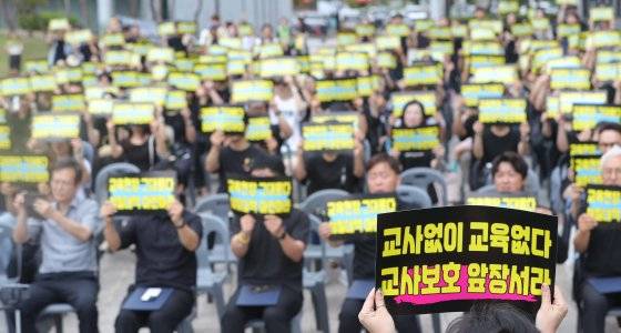 18일 전북 전주시 전북특별자치도교육청에서 열린 서이초 1주기 추모제에서 참석자들이 피켓을 들고 있다. 뉴스1