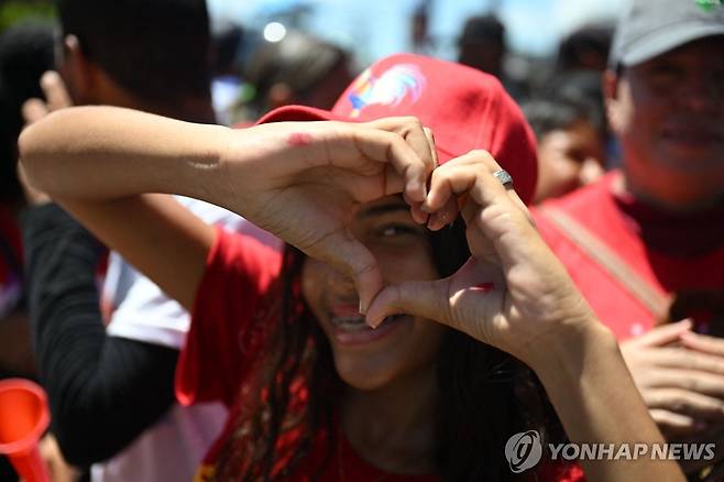 베네수엘라 대선 유세장의 손 하트 (마라카이보 AFP=연합뉴스) 베네수엘라 대선 유세 마지막 날인 25일(현지시간) 마라카이보 지역 여당 대선 유세장에서 한 마두로 대통령 지지자가 손가락 하트를 만들고 있다. 2024.7.26