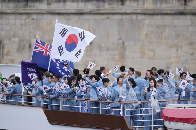 2024 파리 올림픽 개회식이 열린 26일(현지시간) 프랑스 파리 센강에서 대한민국 선수단의 기수 우상혁(오른쪽)과 김서영이 보트를 타고 트로카데로 광장을 향해 수상 행진을 하고 있다. AP연합뉴스