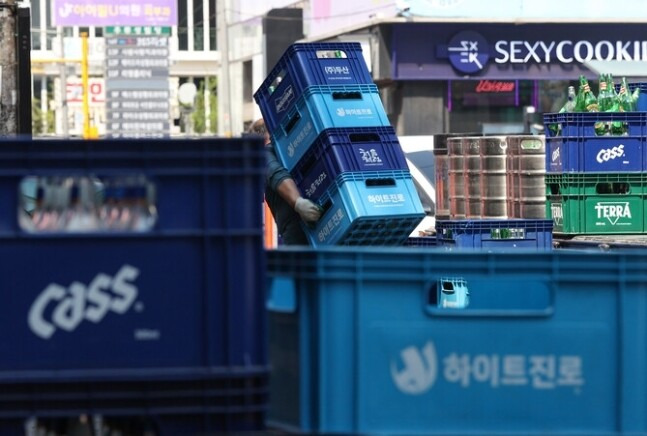 서울 시내 한 식당가에서 주류 업자가 주류 상자를 옮기고 있다. 연합뉴스