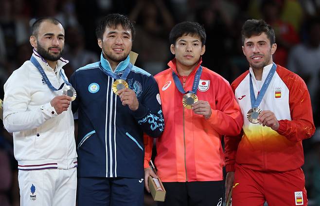 프란시스코 가리고스(스페인·오른쪽)가 동메달을 들고 환하게 웃고 있지만, 나가야마 류주(일본·오른쪽에서 두번째)는 무표정하다. /로이터 연합뉴스