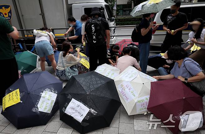 티몬과 위메프의 정산·환불 지연 사태가 지속되고 있는 28일 오후 서울 강남구 큐텐 본사 앞에서 피해자들이 사태 해결을 촉구하는 문구를 우산에 붙이며 시위를 준비하고 있다. 2024.7.28/뉴스1 ⓒ News1 장수영 기자