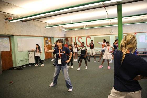 월드비전 봉사자들이 지난 4일 미국 매사추세츠주 브록턴의 한 중학교에서 K팝 아이돌 '뉴진스' 노래 '수퍼샤이'에 맞춰 이민자 가정 학생들에게 춤을 가르치고 있다. 사진 월드비전