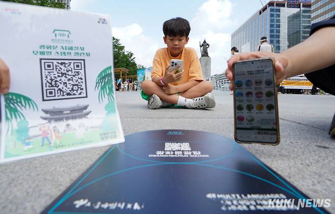 광화문광장 탐구생활 프로그램이 다음달 5일부터 11일까지 운영되는 가운데 30일 서울 광화문광장 이순신장군 동상 앞에서 시연 행사가 열려 한 어린이가 AI 해설사 스탬프 투어 체험을 하고 있다.
