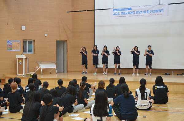 마산무학여중 학생들이 30일 체육관에서 인근 초등학교 학생들과 함께 킨볼 심판 수신호와 규칙 등을 배우고 있다. /이동욱 기자