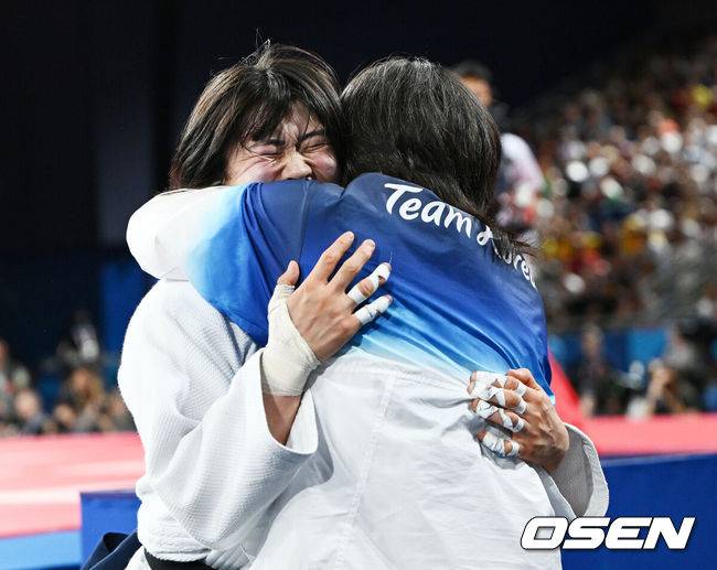 [OSEN=파리(프랑스), 최규한 기자] 29일(한국시간) 프랑스 파리 샹드마르스 아레나에서 ‘2024 파리올림픽’ 여자 유도 57kg 4강 경기 한국 허미미와 브라질 하파엘라 실바의 경기가 열렸다.한국 유도 기대주 허미미는 한국 국적 아버지와 일본 국적 어머니 사이에서&nbsp;일본 도쿄에서 태어났다. 그는 할머니의 유언을 따라 한국에서 선수 생활을 시작해 태극 마크까지 달게 됐다.허미미가 승리한 뒤 김미정 감독과 포옹을 하고 있다. 2024.07.29 / dreamer@osen.co.kr