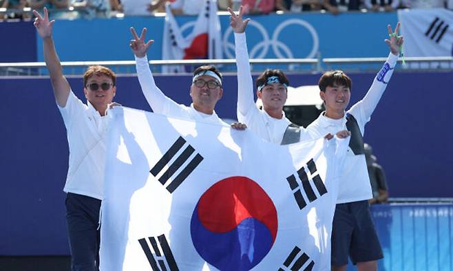 29일(현지시간) 프랑스 파리 레쟁발리드 양궁 경기장에서 열린 2024 파리 올림픽 양궁 남자 단체 결승전 한국과 프랑스의 경기. 금메달을 차지한 한국 대표팀 선수들이 태극기를 들고 세리머니하고 있다. 연합뉴스