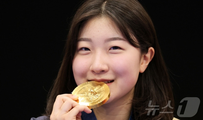 대한민국 사격 대표팀 반효진이 29일(한국시간) 프랑스 샤토루 슈팅 센터에서 열린 2024 파리올림픽 사격 공기소총 10m 여자 시상식에서 금메달을 입에 물며 미소를 짓고 있다. /사진=뉴스1