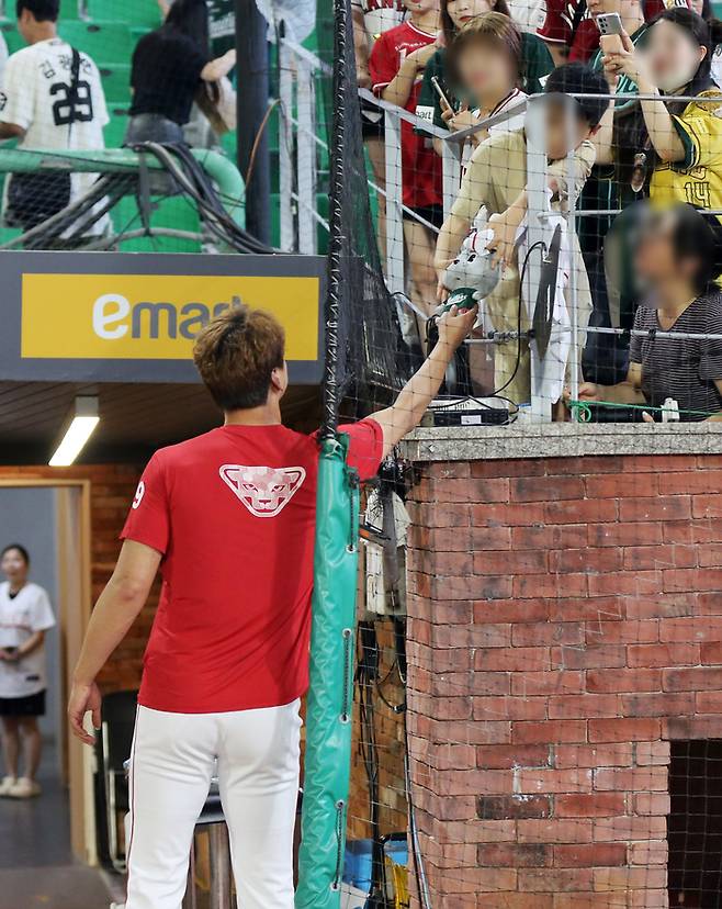 SSG 김광현이 30일 인천SSG랜더스필드에서 열린 2024 KBO리그 롯데전 승리 후 팬에게 인형을 선물하고 있다. 사진 | SSG 랜더스