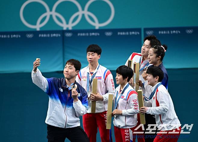 한국 탁구 혼성 복식 임종훈(한국거래소)-신유빈(대한항공) 조는 30일(한국시간) 프랑스 파리 사우스 파리 아레나 4에서 열린 홍콩의 치우당-니나 미텔함 조와의 혼합 복식 동메달 결정전에서?웡춘팅-두호이켐 조(홍콩, 세계 랭킹 4위)를 상대로 4-0(11-5 11-7 11-7 14-12)으로 완승을 거두면서 값진 동메달을 차지했다. 동메달을 거머쥔 한국 임종훈-신유빈이 금메달 중국 왕추친-쑨잉사, 은메달 북한 리정식-김금용과 함께 기념사진을 찍고 있다. 파리(프랑스)=정재근 기자 cjg@sportschosun.com/2024.07.30/