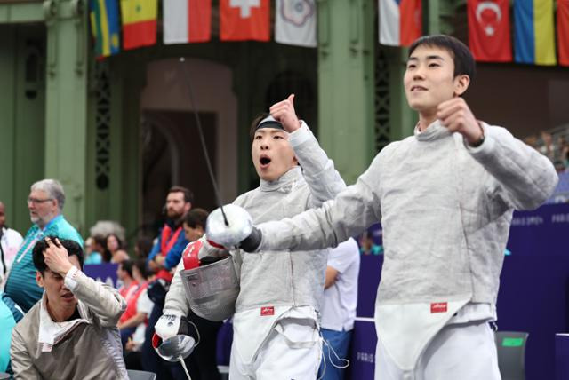 한국 펜싱 남자 사브르 대표팀의 박상원과 도경동이 31일 프랑스 파리 그랑팔레에서 열린 2024 파리 올림픽 펜싱 남자 사브르 단체 8강전에서 캐나다 파레스 아르파를 이긴 오상욱을 향해 환호하고 있다. 파리=연합뉴스