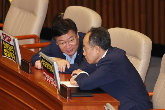 국민의힘 추경호 원내대표(오른쪽)와 정점식 정책위의장이 30일 오전 '방송 4법'인 교육방송공사법(EBS법) 개정안을 반대하는 같은 당 정성국 의원의 필리버스터가 진행 중인 국회 본회의장에서 대화하고 있다. 연합뉴스