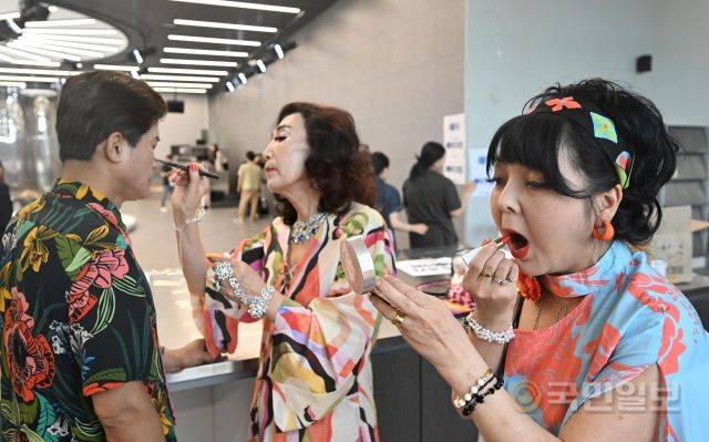 시니어모델들이 서로를 도와가며 메이크업을 수정해주고 있다.