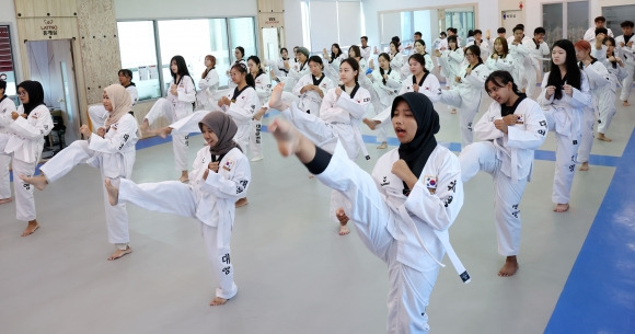 ‘한국 체험 계절학기’ 참가한 외국인 대학생들 - 국립부경대 국제교류본부가 주관한 ‘2024학년도 부경국제계절학기’에 참가한 외국인 대학생들이 30일 부산 남구 대영태권도장에서 태권도 기본 발차기를 배우고 있다. 계절학기는 다음달 14일까지 진행되며 10개국 30개 대학의 학생 200여명이 참가, 8개 교과목과 한국 전통문화 체험, 해양스포츠 체험 등을 이수하고 학점을 받는다. 부산 뉴시스