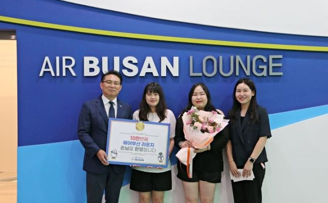 1일 김해공항 에어부산 라운지에서 에어부산 마호진(왼쪽에서 첫번째) 영업본부장과 관계자가 10만 번째 입장객에게 국제선 왕복항공권과 기념품을 전달한 후 기념 촬영을 하고 있다.ⓒ에어부산