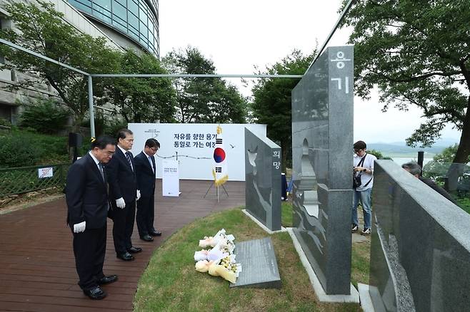 1일 경기도 파주의 오두산 통일전망대에서 열린 ‘북한이탈주민의 날’ 기념비 제막식에서 주요 참석자들이 묵념을 하고 있다. 왼쪽부터 태영호 민주평화통일자문회의 사무처장, 김영호 통일부 장관, 지성호 전 국민의힘 의원. 통일부