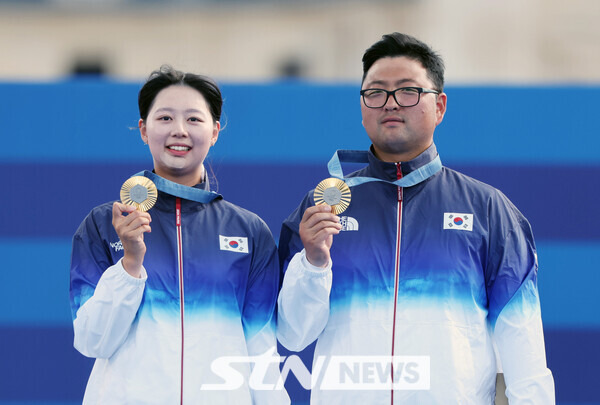 김우진과 임시현이 2일(현지시각) 프랑스 파리 레쟁발리드에서 열린 2024 파리 올림픽 양궁 혼성 단체 시상식에서 금메달을 목에 걸고 기뻐하고 있다. 사진┃파리=뉴시스