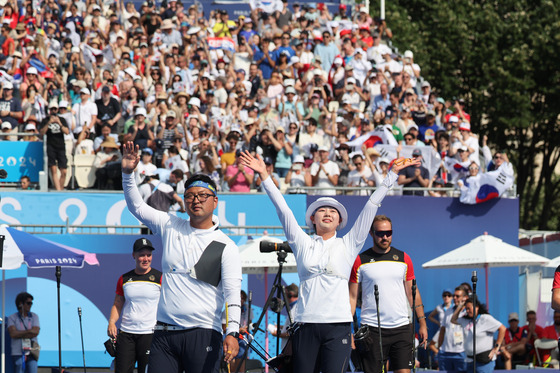 Korea's Lim Si-hyeon and Kim Woo-jin celebrate after winning the mixed team archery event at the Paris Olympics in Paris on Friday.  [YONHAP]