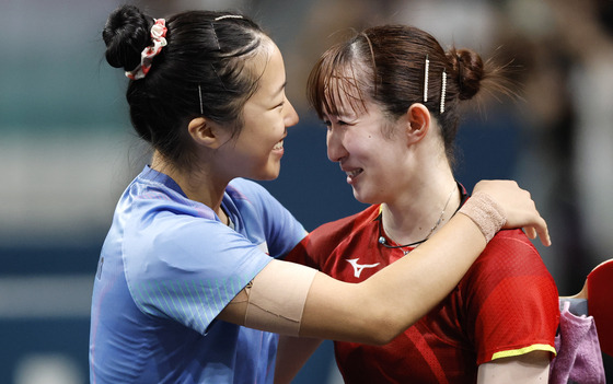 Hina Hayata of Japan, right, hugs Shin Yu-bin of Korea after winning their women singles bronze medal match in Paris on Saturday.  [EPA/YONHAP]