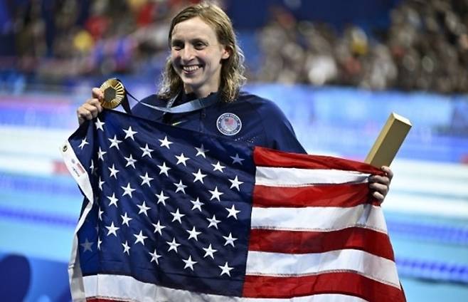 미국 여자 수영 선수&nbsp;케이티 러데키가 1일 파리 올림픽 자유형 1500m 결승전에서 금메달을 획득한 뒤 미국 국기를 흔들며 기뻐하고 있다. 신화뉴시스