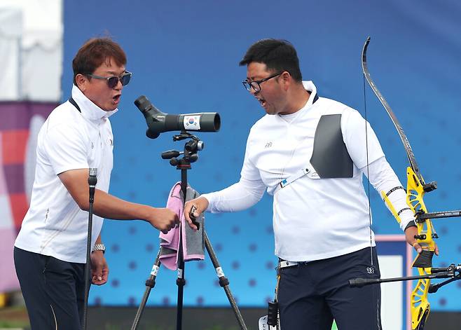 김우진(오른쪽)이 4일(현지시각) 프랑스 파리 레쟁발리드에서 열린 2024 파리올림픽 양궁 남자 개인전 브라질의 마르쿠스 달메이다와의 16강에서 김성수 감독과 파이팅을 외치고 있다. 파리/연합뉴스