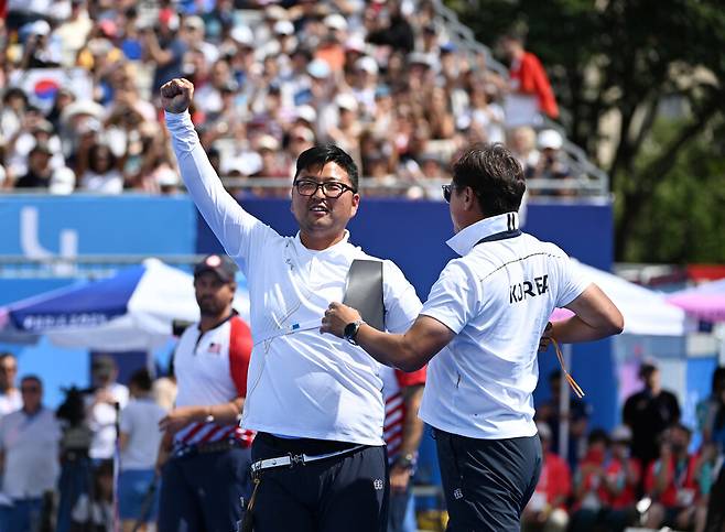 김우진이 4일(현지시각) 프랑스 파리 앵발리드에서 열린 2024 파리올림픽 양궁 남자 개인 결승 미국 브래디 엘리슨과 경기에서 금메달을 확정 지은 뒤 손을 번쩍 들고 있다. 파리/올림픽사진공동취재단