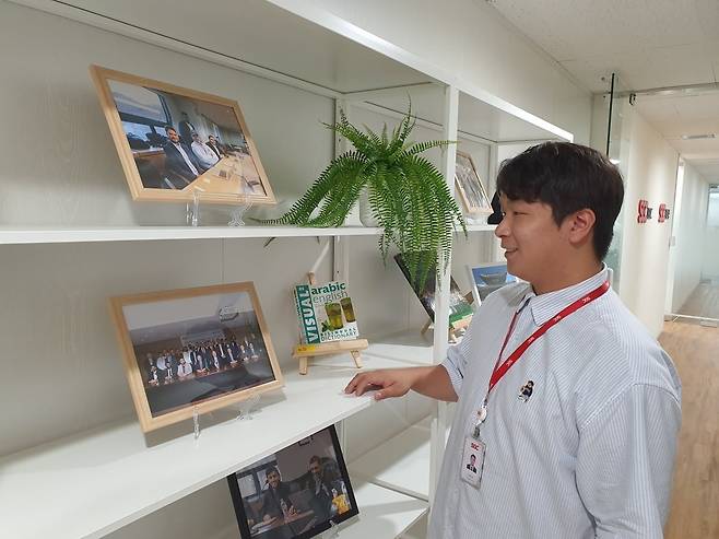 이광주 매니저가 해외 프로젝트 계약 체결식 사진들을 확인하고 있다. 윤현주 기자