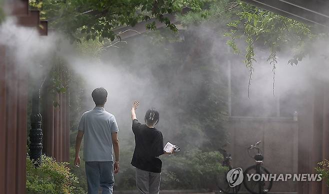 무더위 식히는 쿨링포그 (대구=연합뉴스) 윤관식 기자 = 전국 대부분 지역에 폭염 특보가 발효된 지난 1일 오후 대구 중구 국채보상운동기념공원에 설치된 쿨링포그(안개형 냉각수)밑으로 시민들이 이동하고 있다. 2024.8.1 psik@yna.co.kr