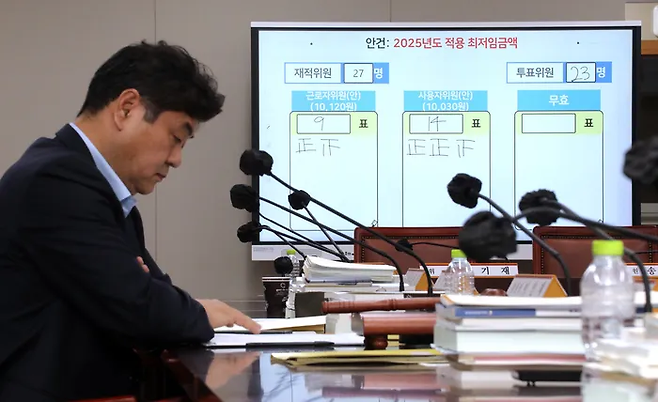 이인재 최저임금위원장이 지난달 12일 새벽 정부세종청사에서 열린 11차 전원회의에서 투표를 거쳐 내년 최저임금을 시간당 1만30원으로 결정된 뒤 자리에서 생각에 잠겨 있다. 연합뉴스