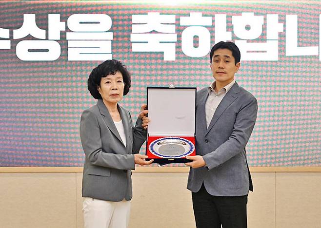 지난 2일 의범학술상을 수상한 이수용 선임연구원(오른쪽)이 고 김용철옹의 장녀 김설매 여사와 기념사진을 찍고 있다.  국방과학연구소 제공