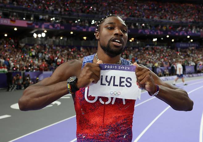 미국의 노아 라일스가 5일(한국시간) 파리 스타드 드 프랑스에서 열린 육상 남자 100m 결선에서 1위로 결승선을 통과한 뒤 자신의 이름이 적힌 이름표를 들어보이고 있다. [신화]