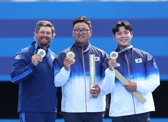 김우진(가운데)과, 미국의 브래이디 엘리슨(왼쪽), 이우석이 4일(한국시간) 프랑스 파리 레쟁발리드 특설 양궁장에서 열린 2024 파리 하계올림픽 양궁 남자 개인전 결승 종료 후 시상식에서 각각 금메달, 은메달, 동메달을 목에 걸고 기뻐하고 있다. 김우진은 이번 대회 남자 단체전, 혼성 단체전에 이어 개인전 우승까지 차지하며 3관왕의 역사를 썼다. 사진 연합뉴스