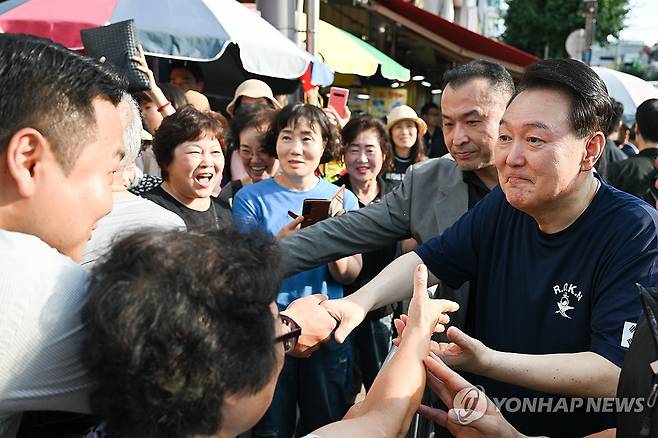 윤석열 대통령, 여름휴가 중 통영중앙시장 방문 (서울=연합뉴스) 진성철 기자 = 여름휴가 중인 윤석열 대통령이 5일 경남 통영시 통영중앙시장을 찾아 상인, 시민들과 인사하고 있다.  2024.8.5   [대통령실 제공. 재판매 및 DB 금지] zjin@yna.co.kr